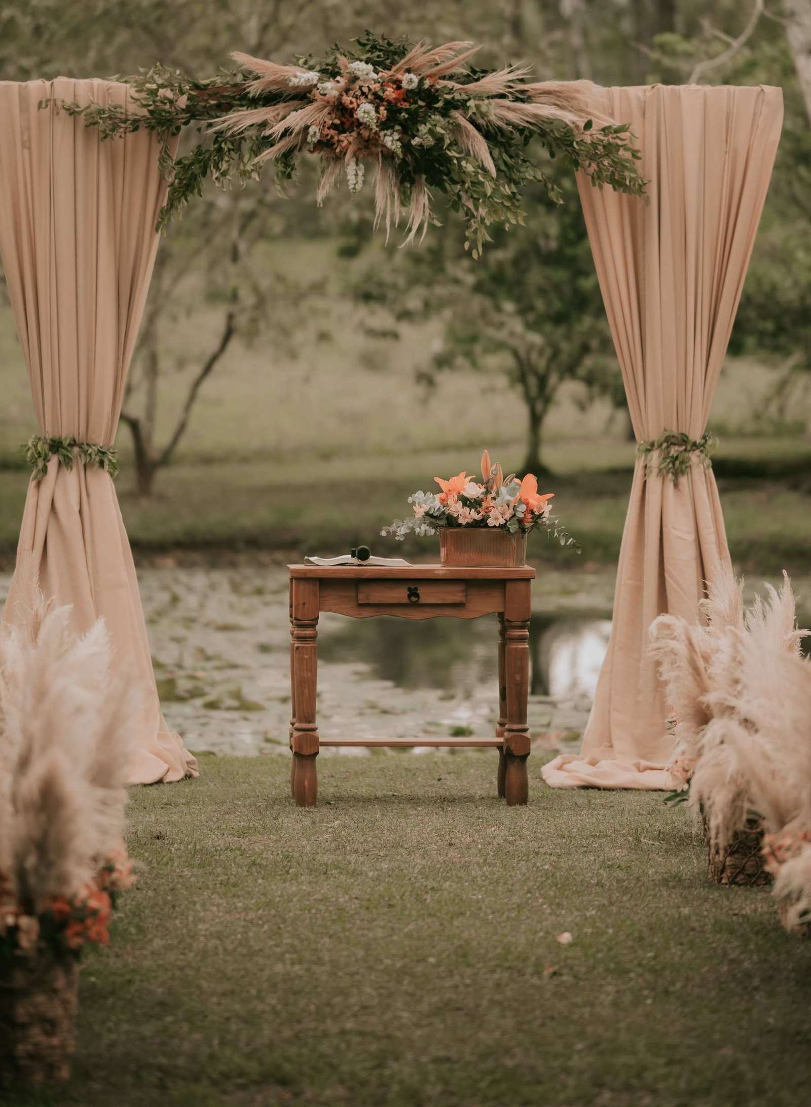Rustic ceremony altar set up by a lake at a destination venue